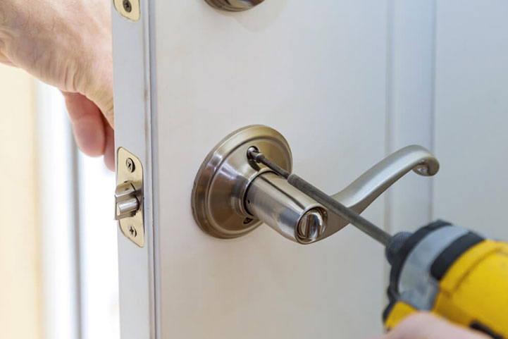 man holding lock repair tools near a door